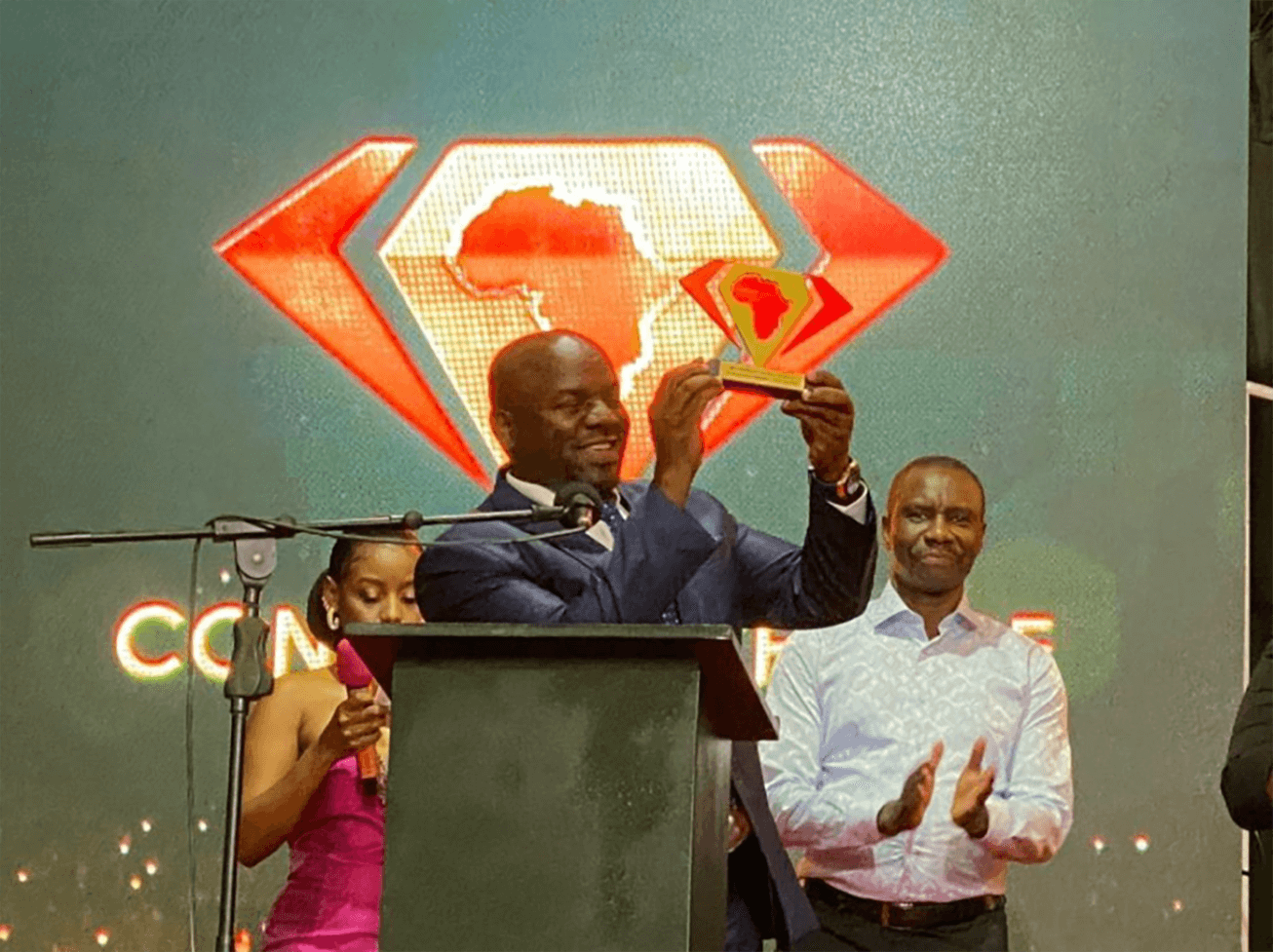 Man on podium holding up a trophy