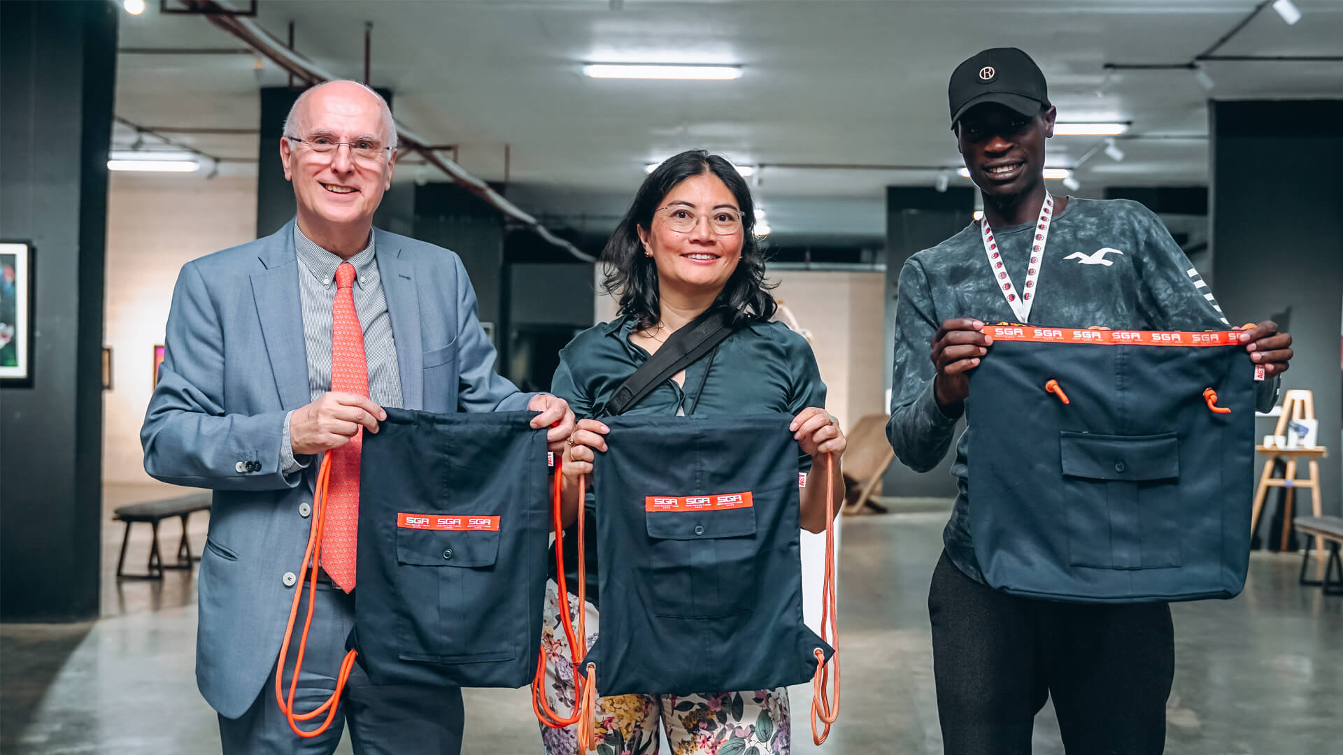 Three SGA Security personnel holding labeled bags